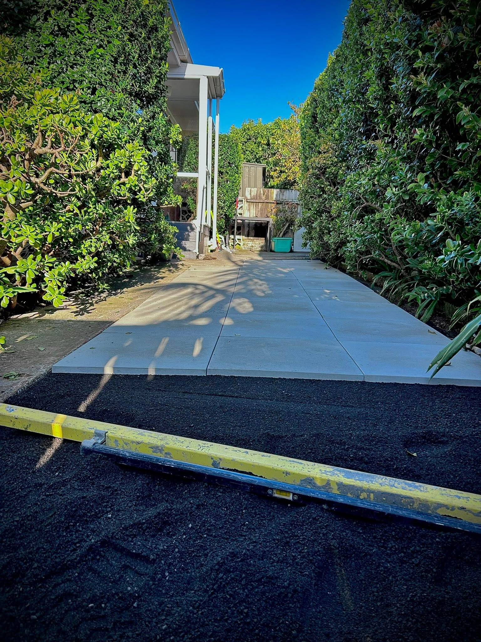 Freshly laid paved pathway between trimmed hedges, Auckland