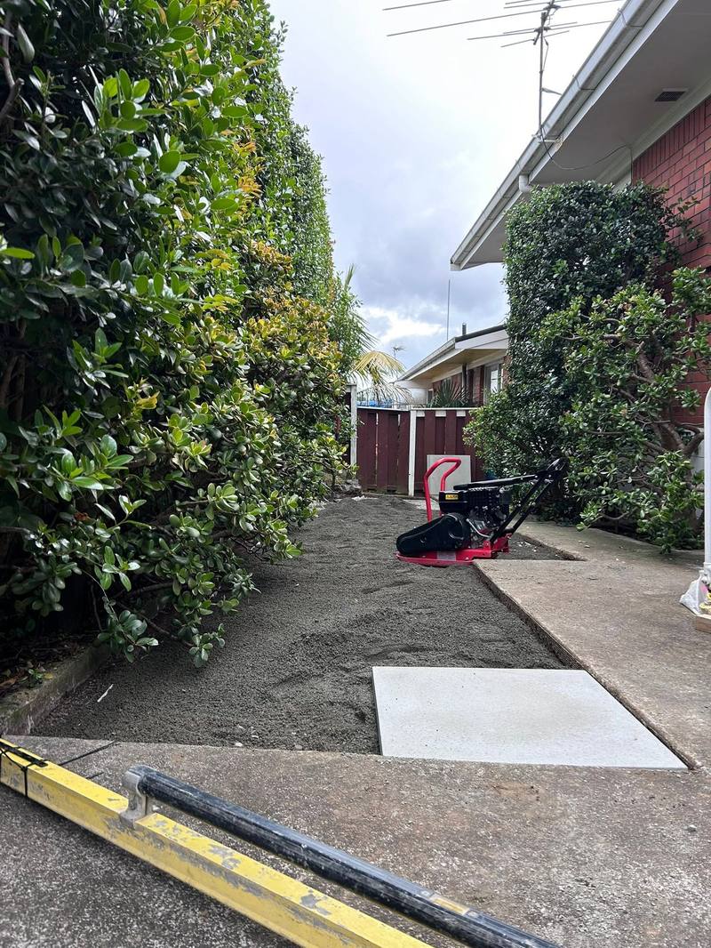 Ground prepared with basecourse and a plate compactor on site